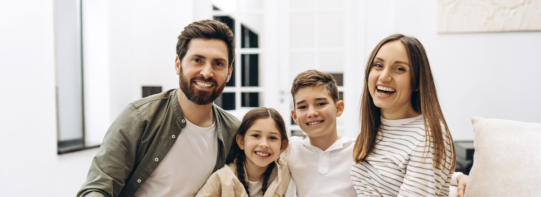 family sitting on a couch smiling