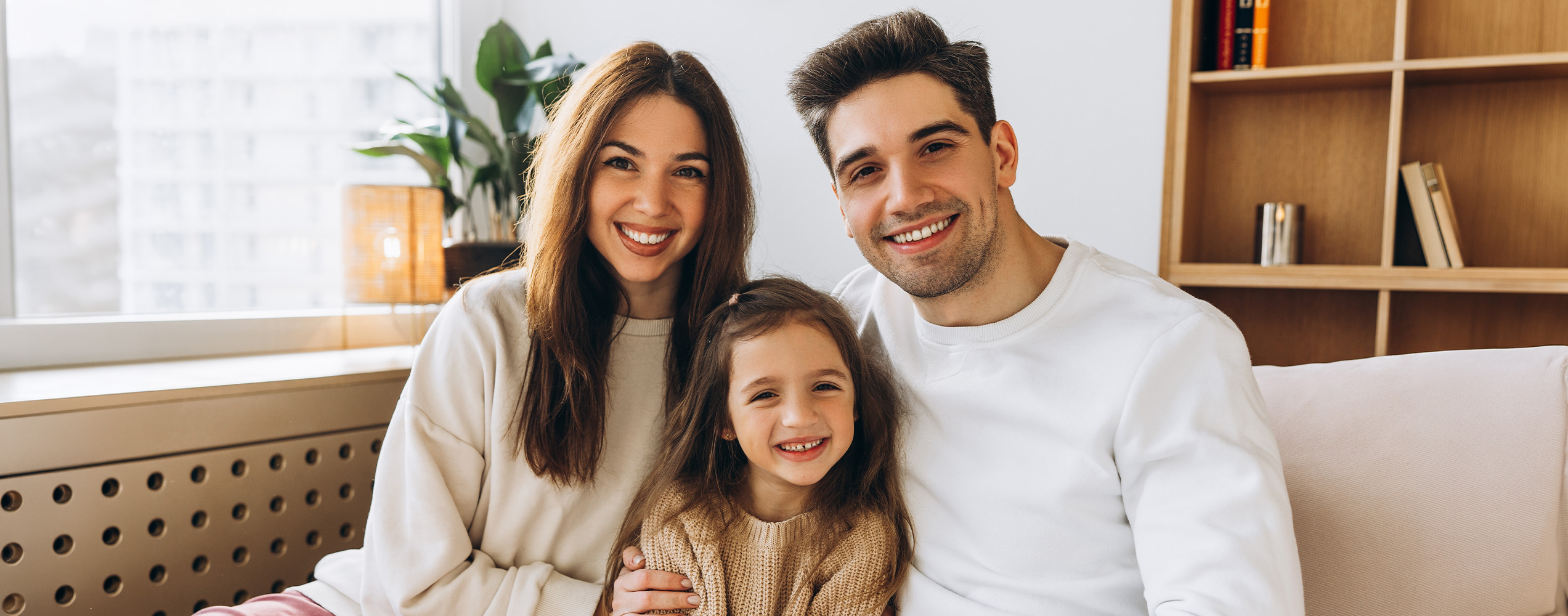 Family sitting together on a couch smiling